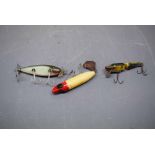 Group of three vintage fishing lures, one inscribed "Heddon Flap-tail" and another "Injured