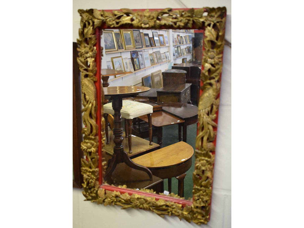 Late 20th century Oriental softwood carved mirror of foliage and birds of paradise with a red