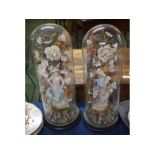 Pair of Victorian glass domes on turned socles, together with a floral and bisque figured