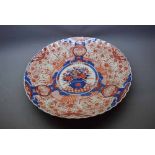 Large Imari charger with scalloped border and central decoration of a vase of flowers, 19ins diam