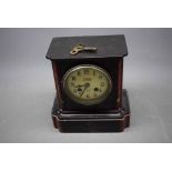 Good quality black slate and marble mantel clock with shaped corners and engraved detail, enamel