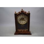 American pine framed arch top mantel clock with enamel Arabic chapter ring with striking bell and