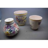 Two Poole Pottery cylindrical vases with painted floral scenes, together with a similar designed