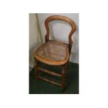 Beechwood framed cane seated child's chair with arched back on four tapering cylindrical turned legs