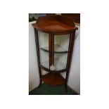 Edwardian mahogany bow-fronted corner cupboard with inlaid detail, open shelf and splayed legs,