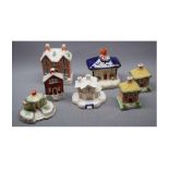 Seven assorted Staffordshire houses, four formed as money boxes and two further pastel burners,