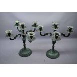 Pair of modern metal and verdigris candlesticks with four shaped arms and central sconce on a