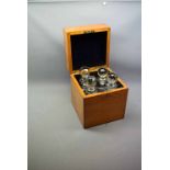 Early 20th century oak decanter box with four square fitted decanters with faceted stoppers, 8ins
