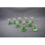 Set of seven 20th century green stemmed wine glasses with clear bowls and gilded detail, together