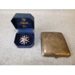 Silver paste set starburst brooch, 3.6cmW, with a silver cigarette case, 115g (3.7ozt) gross