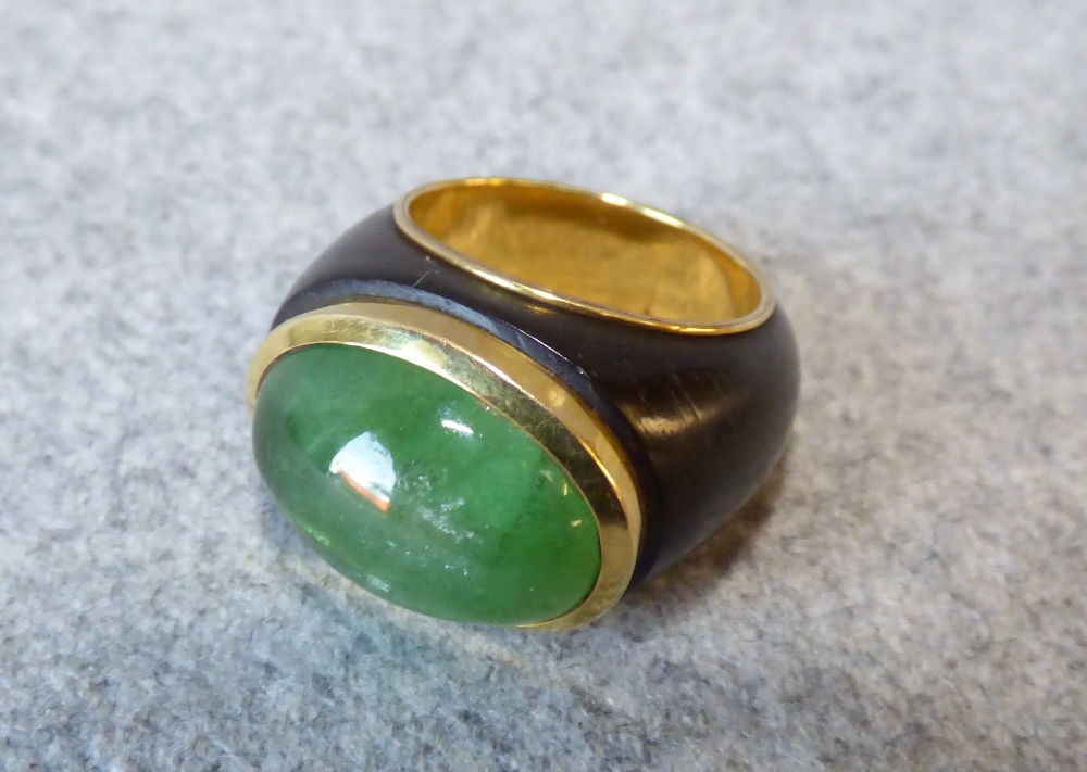 Cabochon emerald dress ring, stamped '750' the emerald 18mmL x 12mmW, to gold lined ebony style