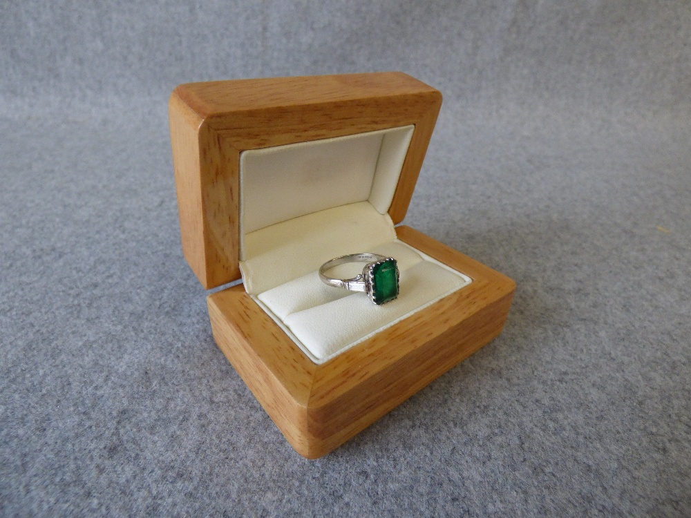 Emerald and diamond platinum ring, 2003, the step cut measuring 10.5mmH x 7.2mmW x 4.9mmD, with a