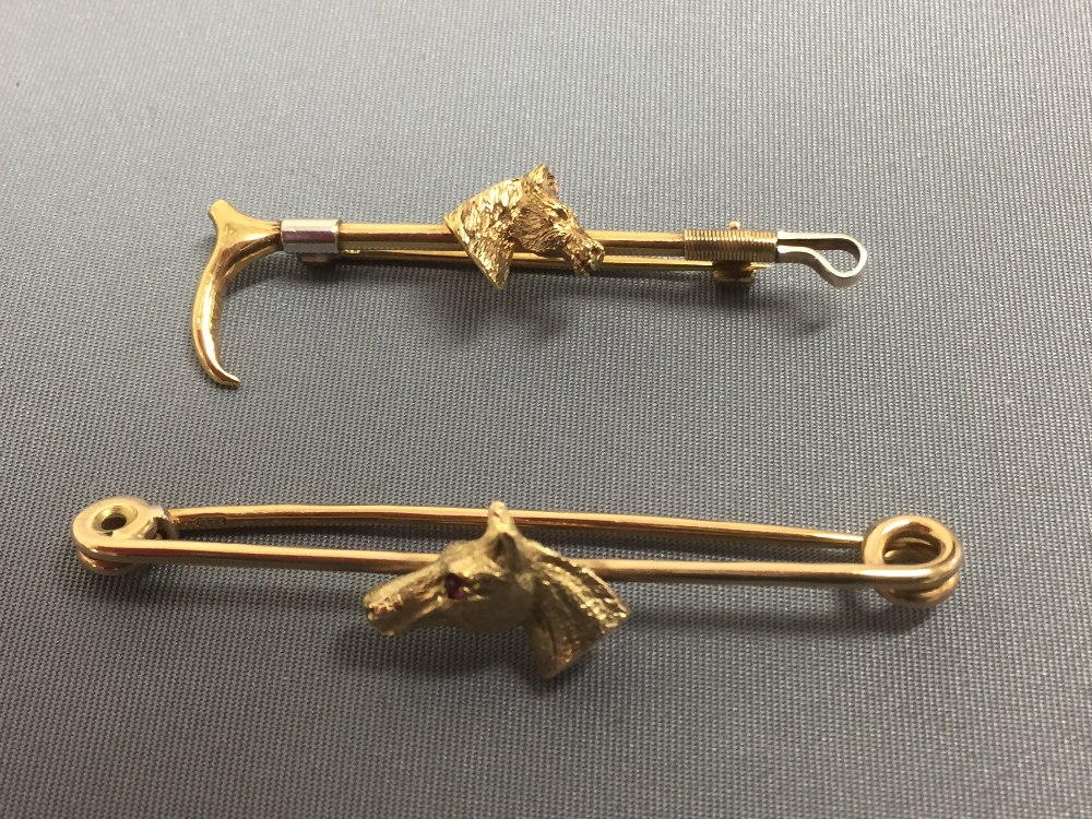 Two colour 9ct gold riding crop brooch, applied with a horse's head, 4.8cm long with a 9ct gold