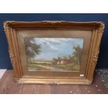 A gilt swept framed oil painting of a pastural scene of riverside cottages set in woodland,