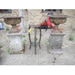 Pair of Victorian cast iron garden urns on weathered composit plinths, 90H x 40D cm