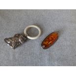 Edwardian white metal child's rattle in the form of a dog & an amber style brooch