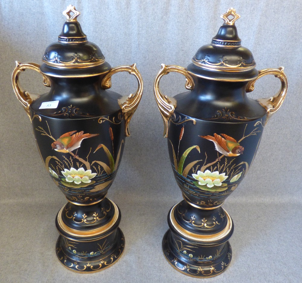 Pair of continental black & gilt glazed urns with bird & floral decoration 68H cm