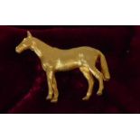 9 carat gold brooch, well modelled in the form of a standing horse, 3.4 cm long, 11.8g gross in