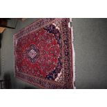 A Persian carpet, claret ground with floral decoration