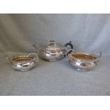 A Georgian silver three piece tea service by 'S. H.' London, 1813, of oval gadrooned form with