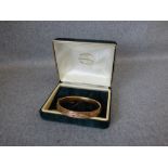 Late Victorian 9 carat gold gem set hinged bangle, Chester 1899, set with alternating red stones and