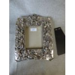 Silver coated photo frame with embossed putti and floral decoration