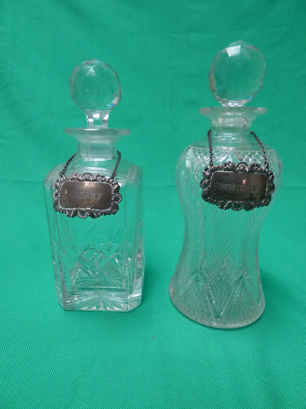 A square cut glass whisky decanter & stopper, a thistle shaped decanter & stopper and two hallmarked