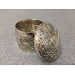 Asian white metal circular pot & lid with embossed floral decoration, 7cm dia.