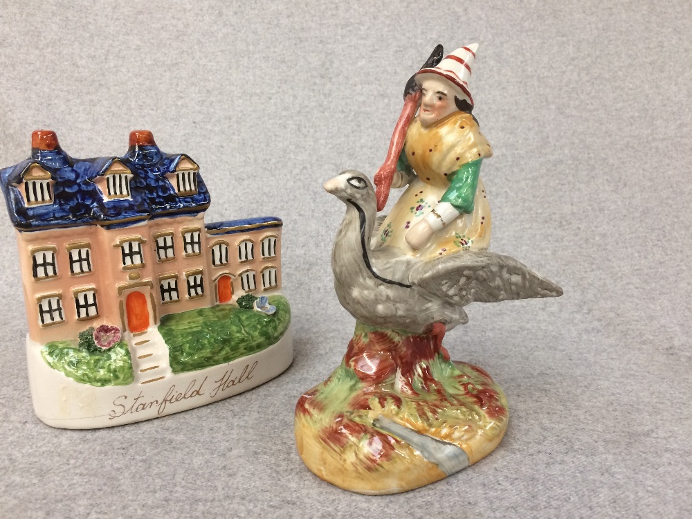 Staffordshire figure of a clown riding a goose and a flat back figure of a house