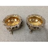 Pair of George V hallmarked silver cast salts with chased borders & shell feet by James Welshman