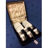 Cased set of Doulton coffee cans & saucers, for 6, in hallmarked silver holders, embossed with
