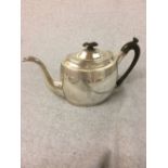 Hallmarked silver oval teapot with ebonised handles with chased decoration