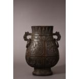 C17th/18th Chinese bronze hu vase, flanked by a pair of chilong handles suspending loose rings, cast