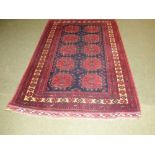 Persian oblong rug and blue central panel of 10 red loztenges with wide terracotta multi border