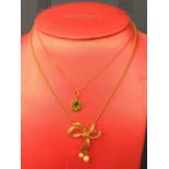 9 carat gold bow motif pendant with cultured pearl drops, on a chain; with a green paste pendant