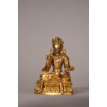 C18th Chinese gilt bronze figure of Buddha, seated on a lotus base and holding a dagger in his right