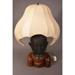 Oriental bronze Buddha head lamp, mounted on wooden stand, fitted for electricity, 58cm high. Please