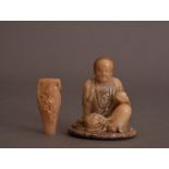 C17th Chinese carved soapstone figure of a Luohan, shown seated on a circular base and holding a