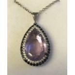 18 carat white gold, pear shaped amethyst surrounded by black and white diamonds