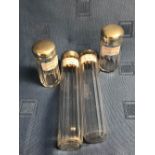 Set of 4 glass ladies vanity bottles with hallmarked silver tops
