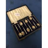 Cased set of 8 enamelled teaspoons with foliate decoration