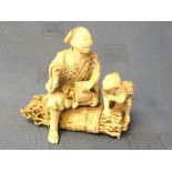 C19th intricately carved ivory Chinese figure group of a man and child on a bundle of sticks, red