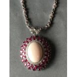 18 carat white gold, ruby and diamond necklace with large central coral cabochon