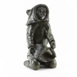 Large Green Stone Inuit Art Sculpture. Depicts a villager kneeling down dressed in traditional