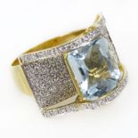 Lady's Chris Cross Cushion Cut Blue Topaz, Pave Set Diamond and 14 Karat Yellow Gold Ring. Topaz