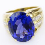 Approximate 12.30 Carat Oval Cut Tanzanite, Princess Cut Diamond and 18 Karat Yellow Gold Ring.