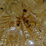 Fine Swarovski Crystal and Gilt 12 Light Chandelier. One faceted prism has a small crack. Measures