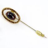 Vintage Garnet and 14 Karat Yellow Gold Stick Pin Set in the Center with an Oval Cabochon Cut Garnet