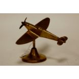 A brass desk ornament in the form of a Spitfire