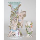 An early 20th century continental porcelain floral encrusted candlestick surmounted by cherub